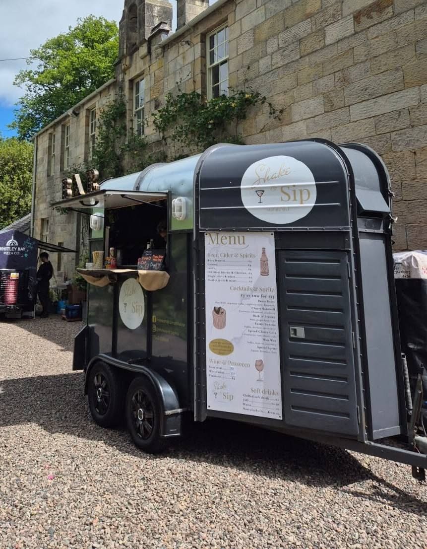 Shake & Sip Horsebox Bar outside a stone venue